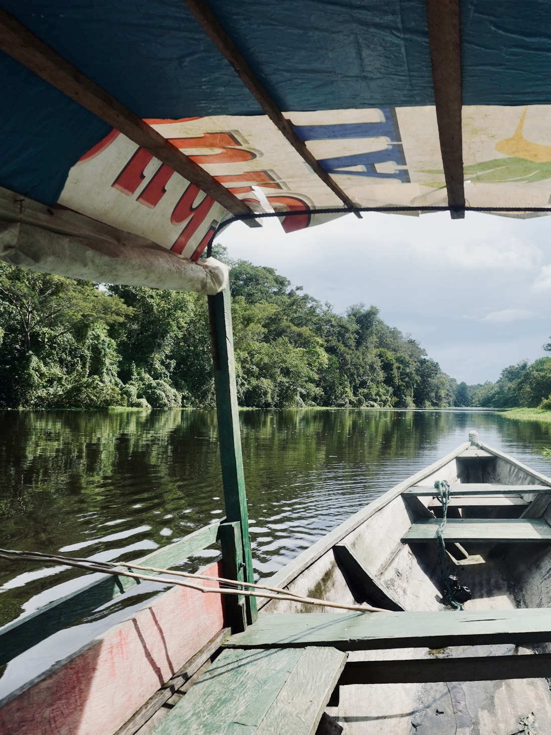 A small boat on calm water surrounded by forest at Gal Oya