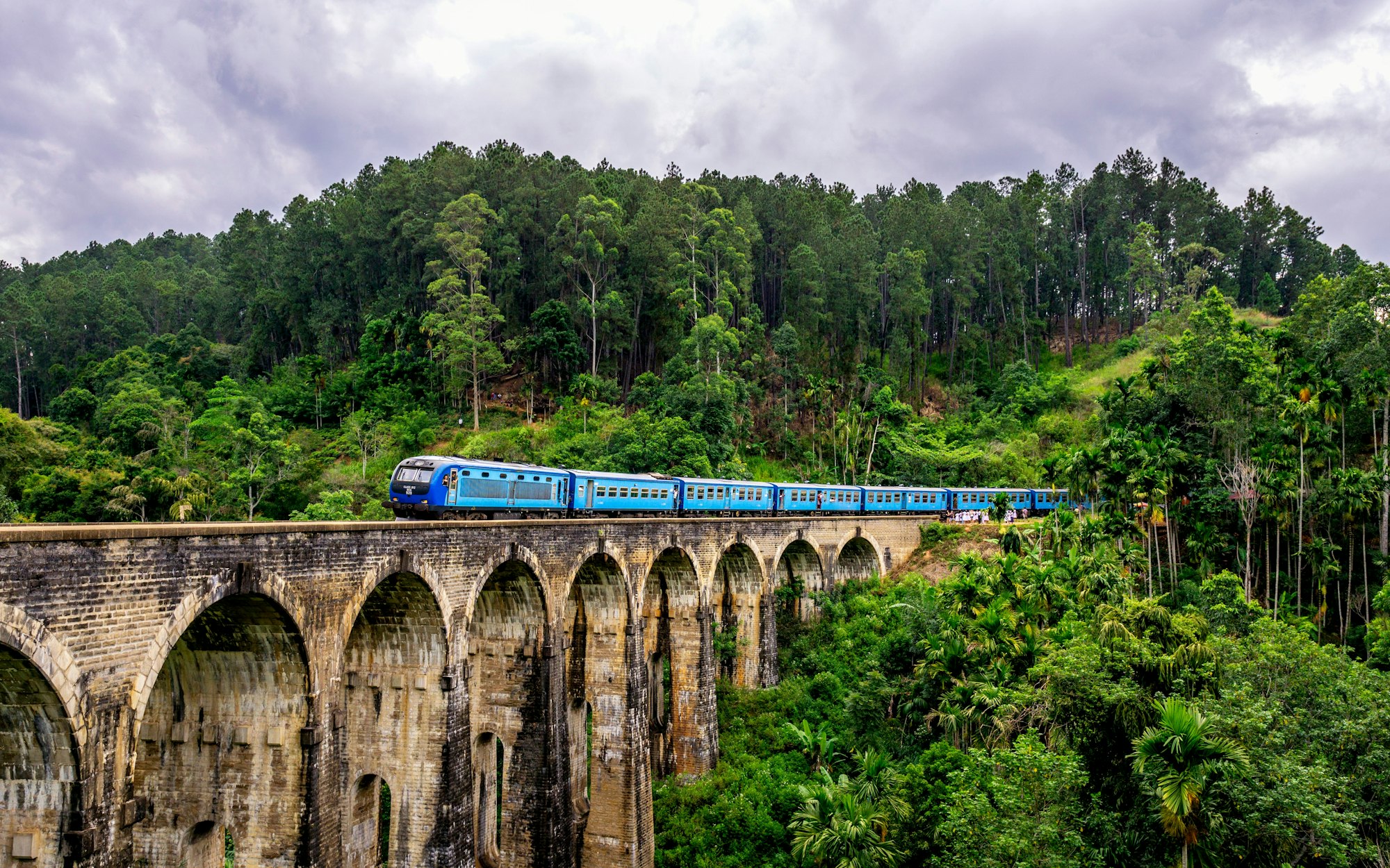 A train crossing the nine-arch stone viaduct in the jungle near Ella